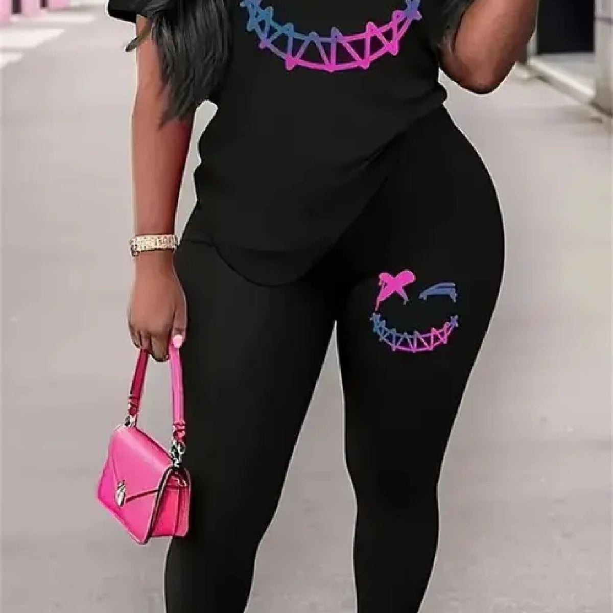 Women two-piece set, featuring a black round-neck top with patterns and black trousers,